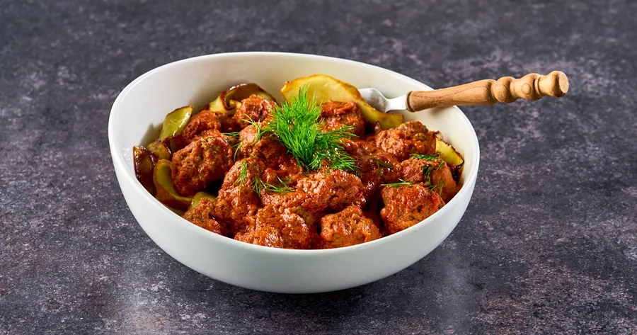 Gehaktballetjes in tomaten-roomsaus met kruidige witte kool