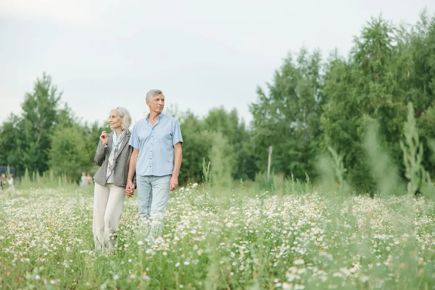 Ouder stel wandelt samen door een veld met bloemen