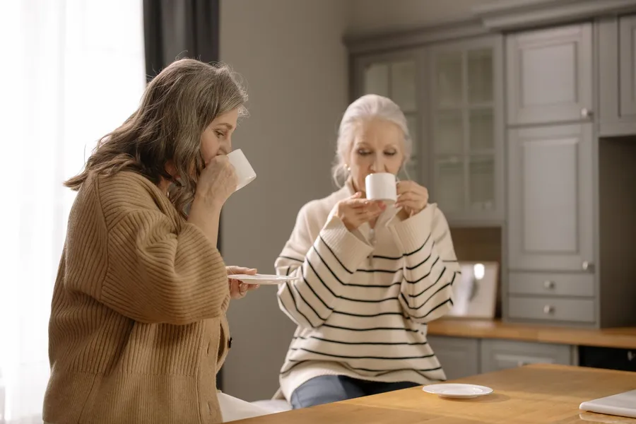 Twee oudere vrouwen drinken samen koffie tegen eenzaamheid