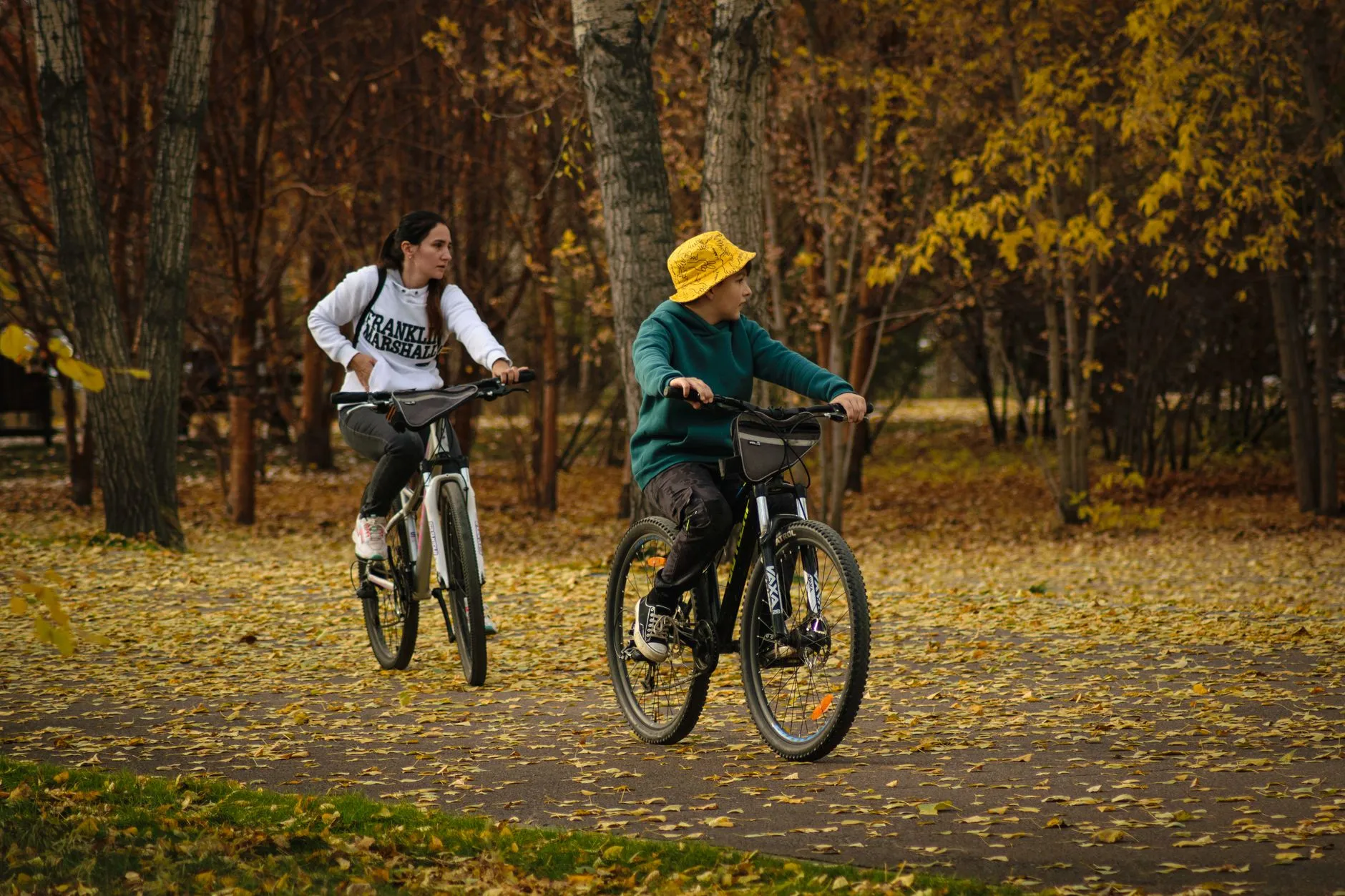 Kind fietst met een ouder door het herfstpark: kinderen bewegen te weinig