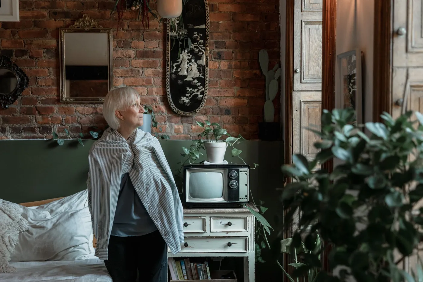Oudere vrouw kijkt rustig uit het raam: leven met schildklierkanker