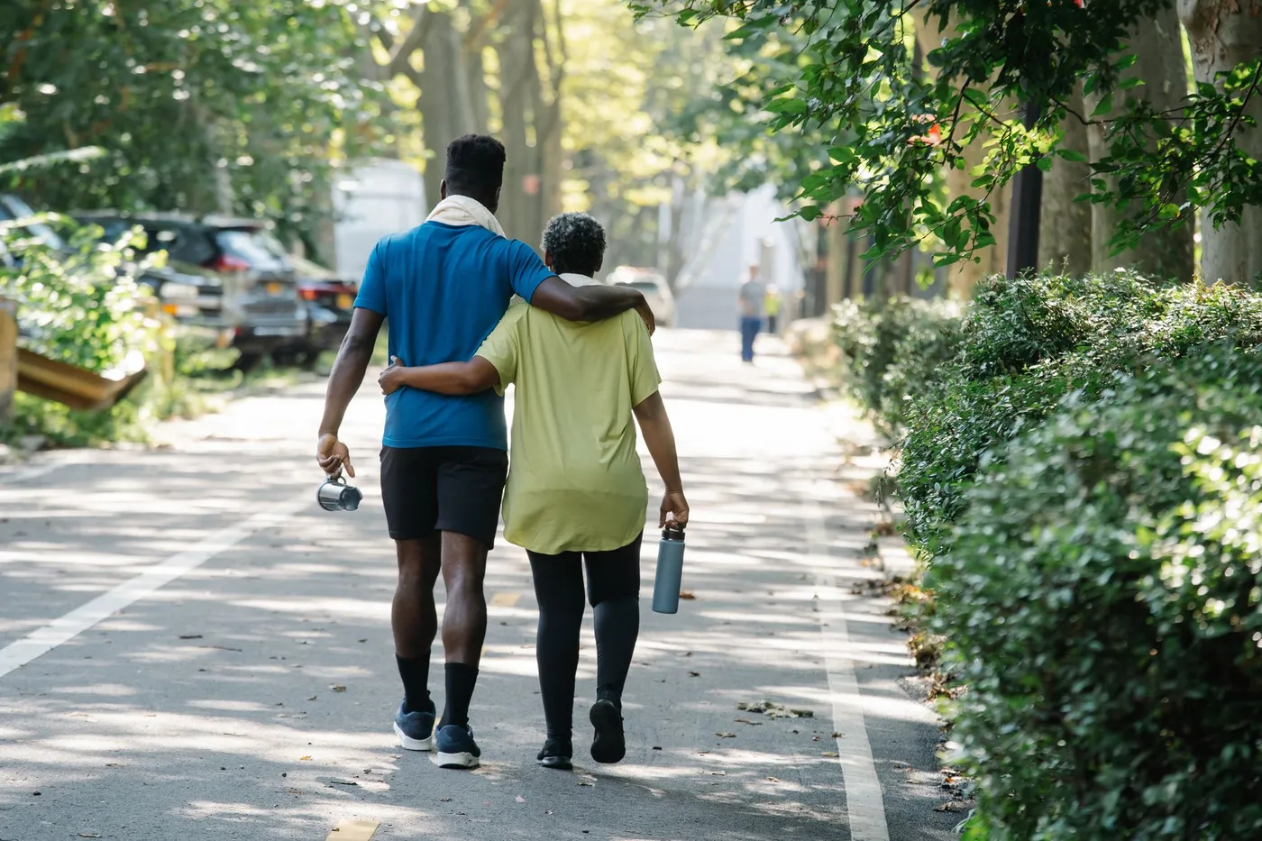 Moeder en volwassen zoon wandelen samen door een park