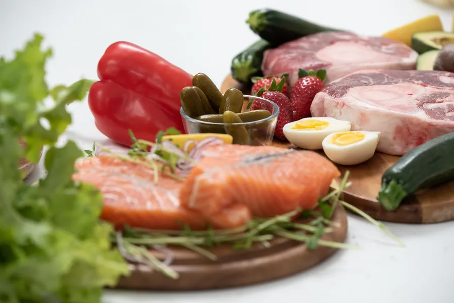 Verse zalm, eieren en groente op een houten plank