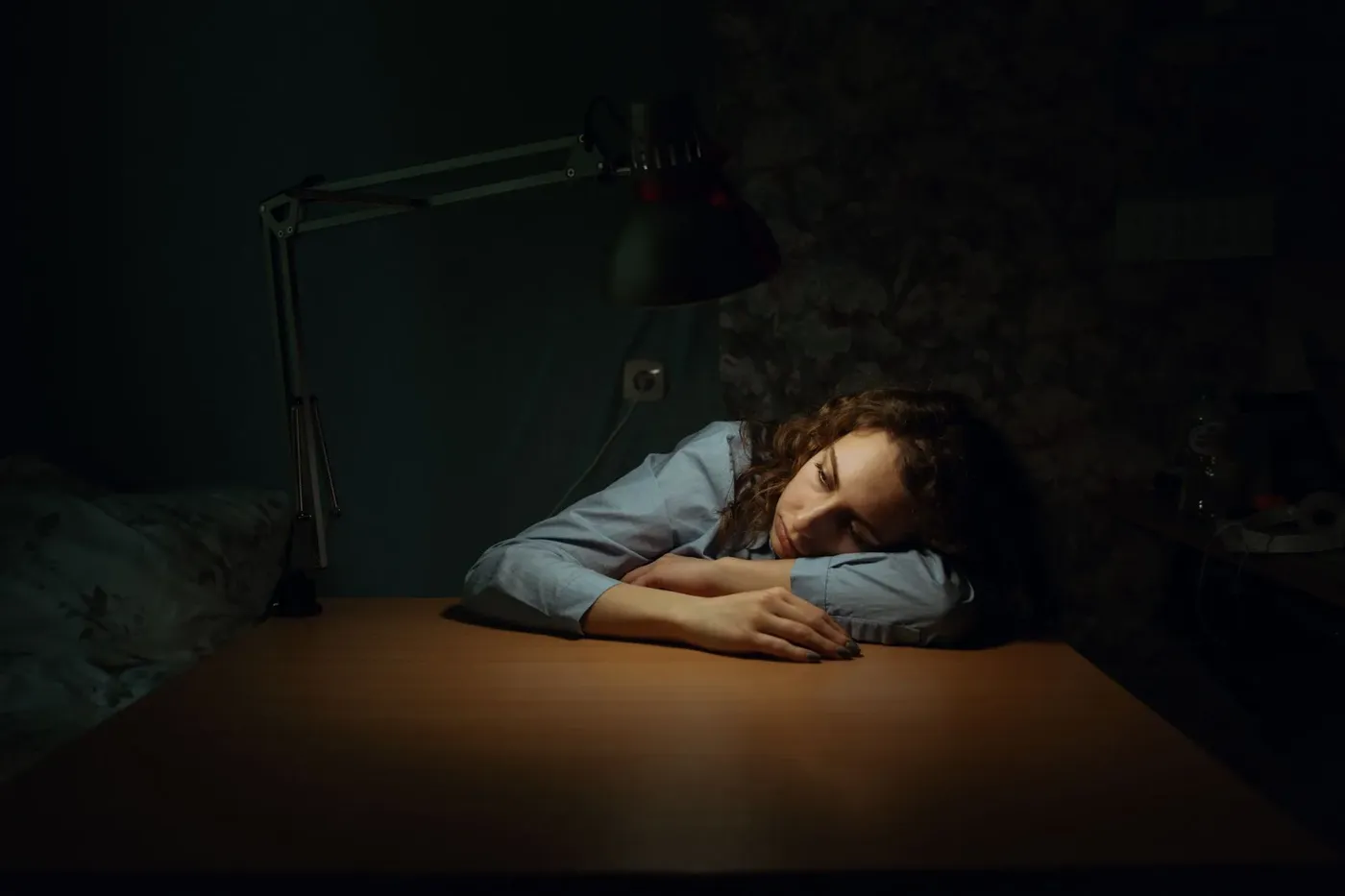 Vermoeide vrouw rust met haar hoofd op een bureau