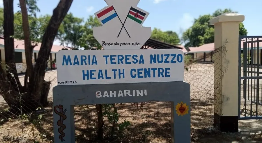 Naambord van het Maria Teresa Nuzzo Health Centre in Baharini, Kenia, met de Nederlandse en Keniaanse vlag