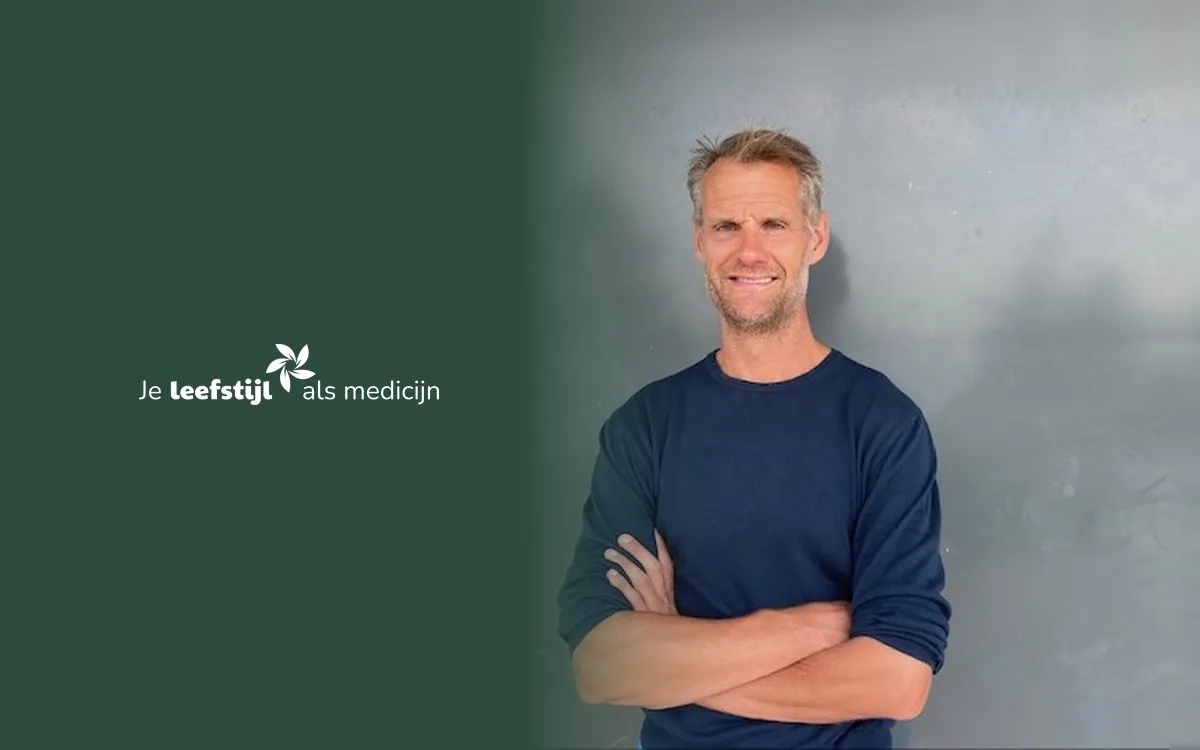 Dr. Nico Weerkamp, neuroloog en bewegingswetenschapper, met gekruiste armen voor een grijze muur