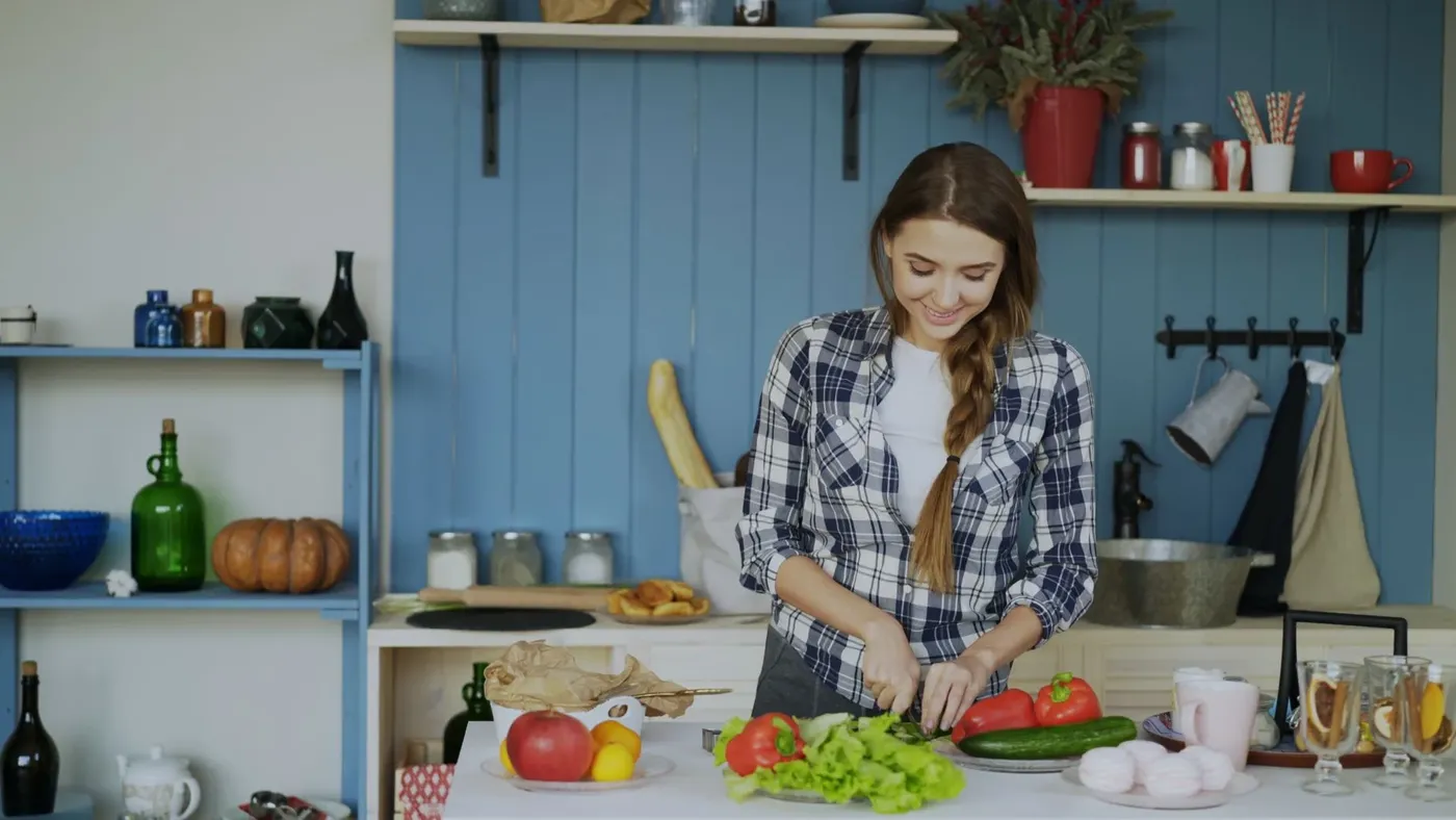 Vrouw snijdt groente in een gezellige keuken