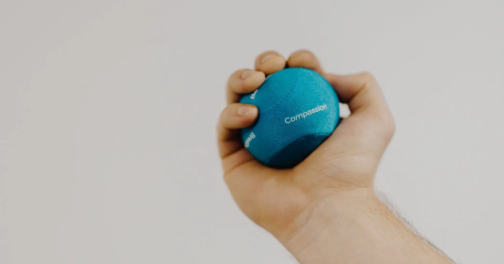Hand knijpt in een blauwe bal