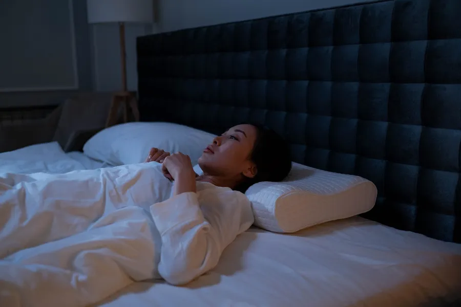 Vrouw ligt wakker in bed
