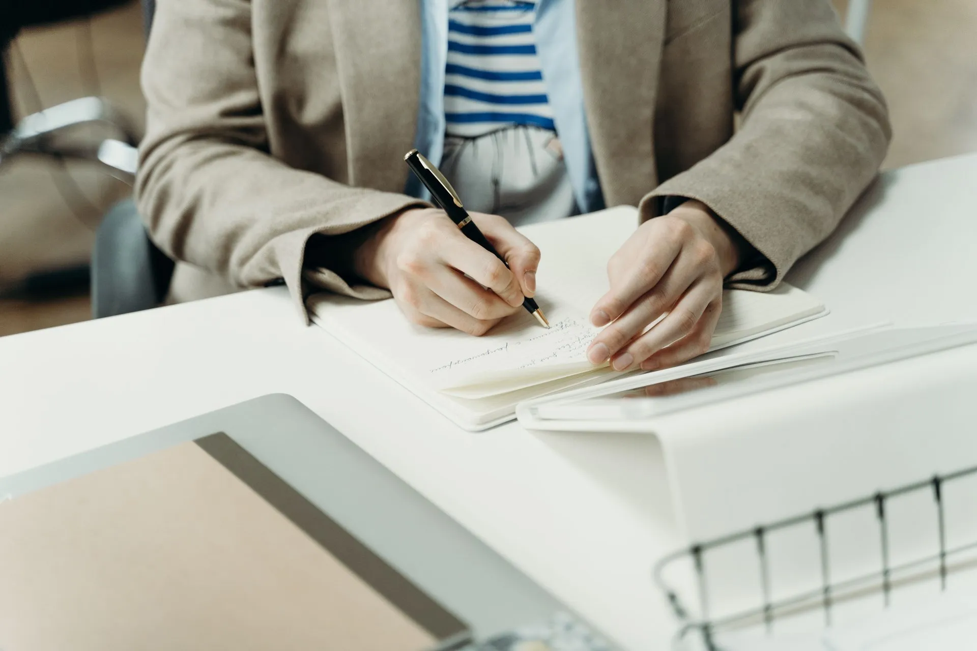Persoon schrijft in een notitieboek