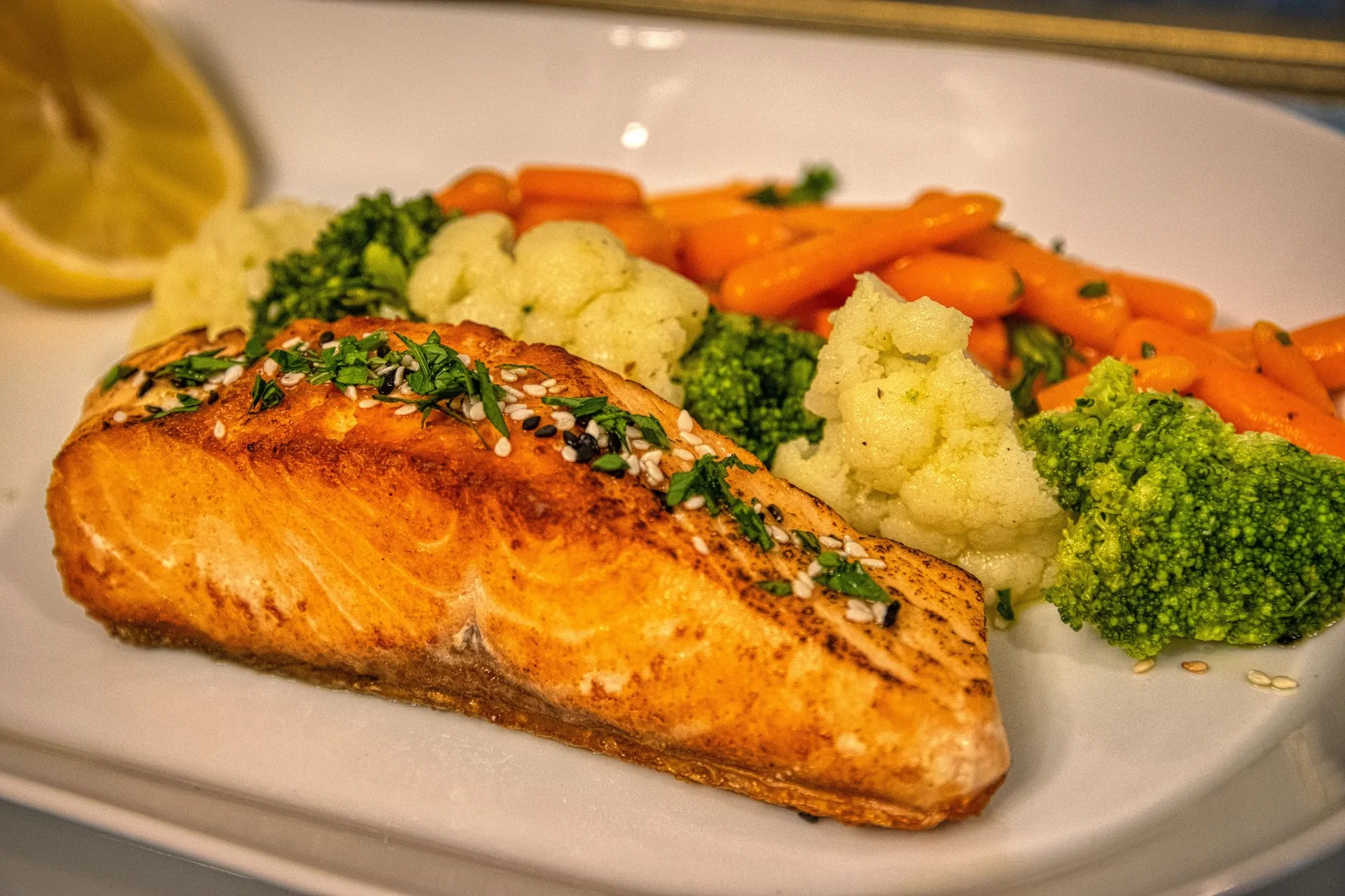 Zalm met broccoli, bloemkool en wortel op een bord