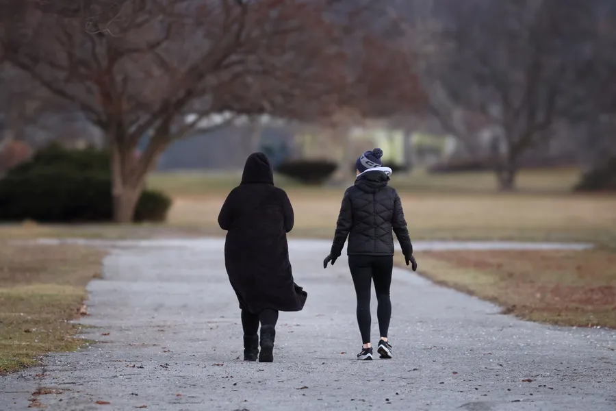 Twee vrouwen wandelen samen over een parkpad