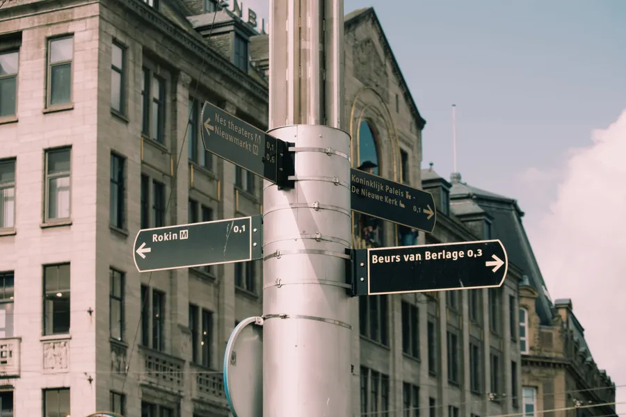 Wegwijzers naar verschillende bestemmingen in Amsterdam