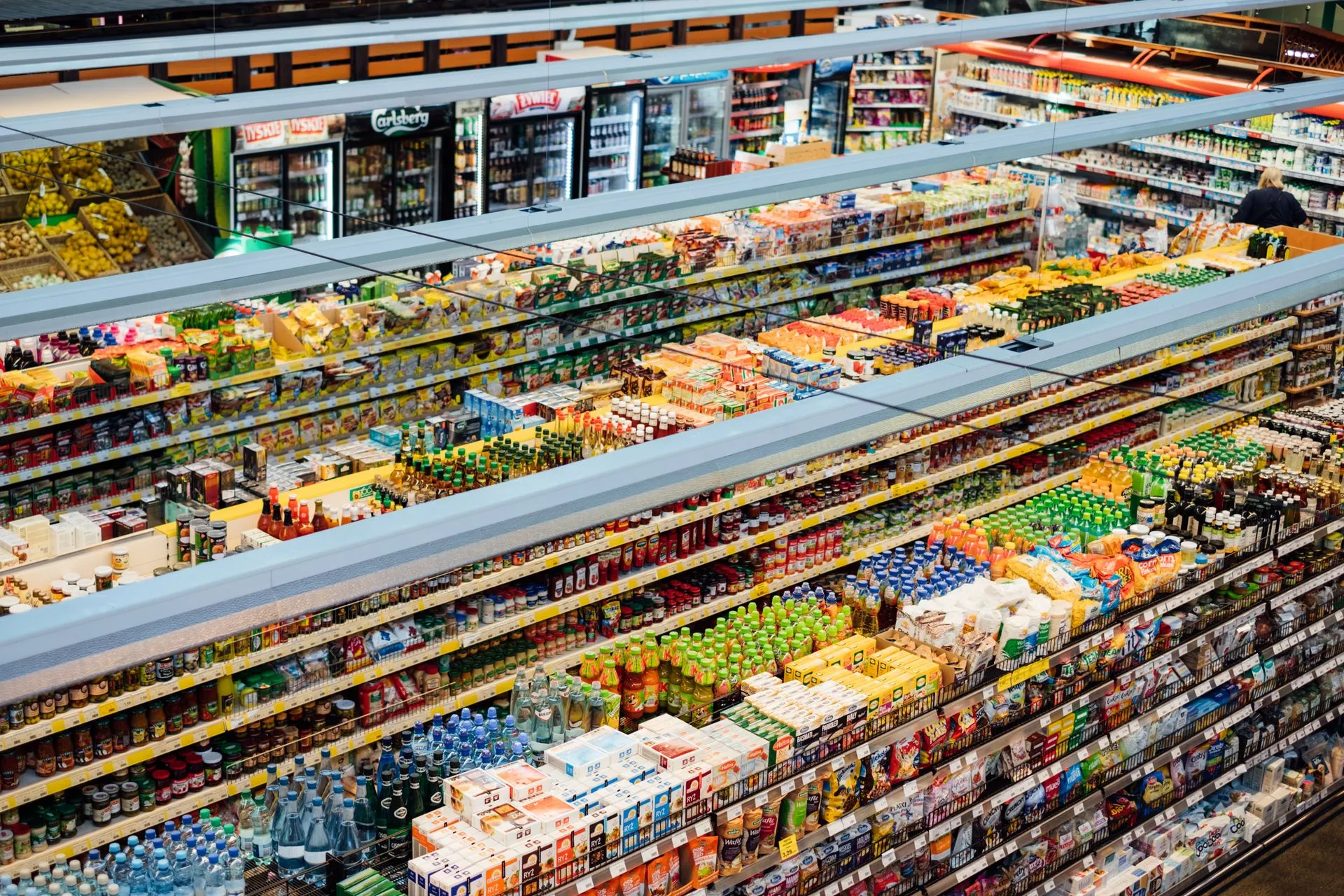 Volle, kleurrijke schappen van een supermarkt, gezien van bovenaf.