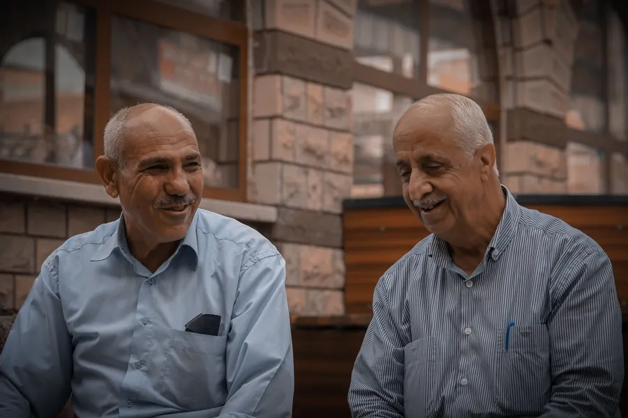 Twee oudere mannen praten en lachen samen