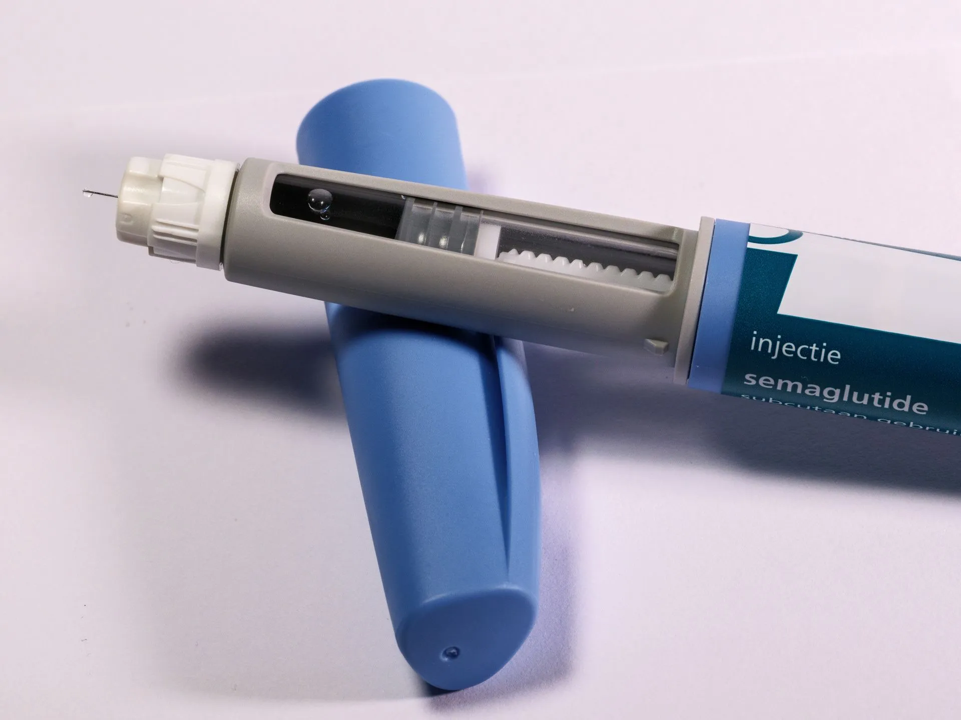 Injectiepen met semaglutide, veel gebruikt bij diabetes, tegen een egale achtergrond.