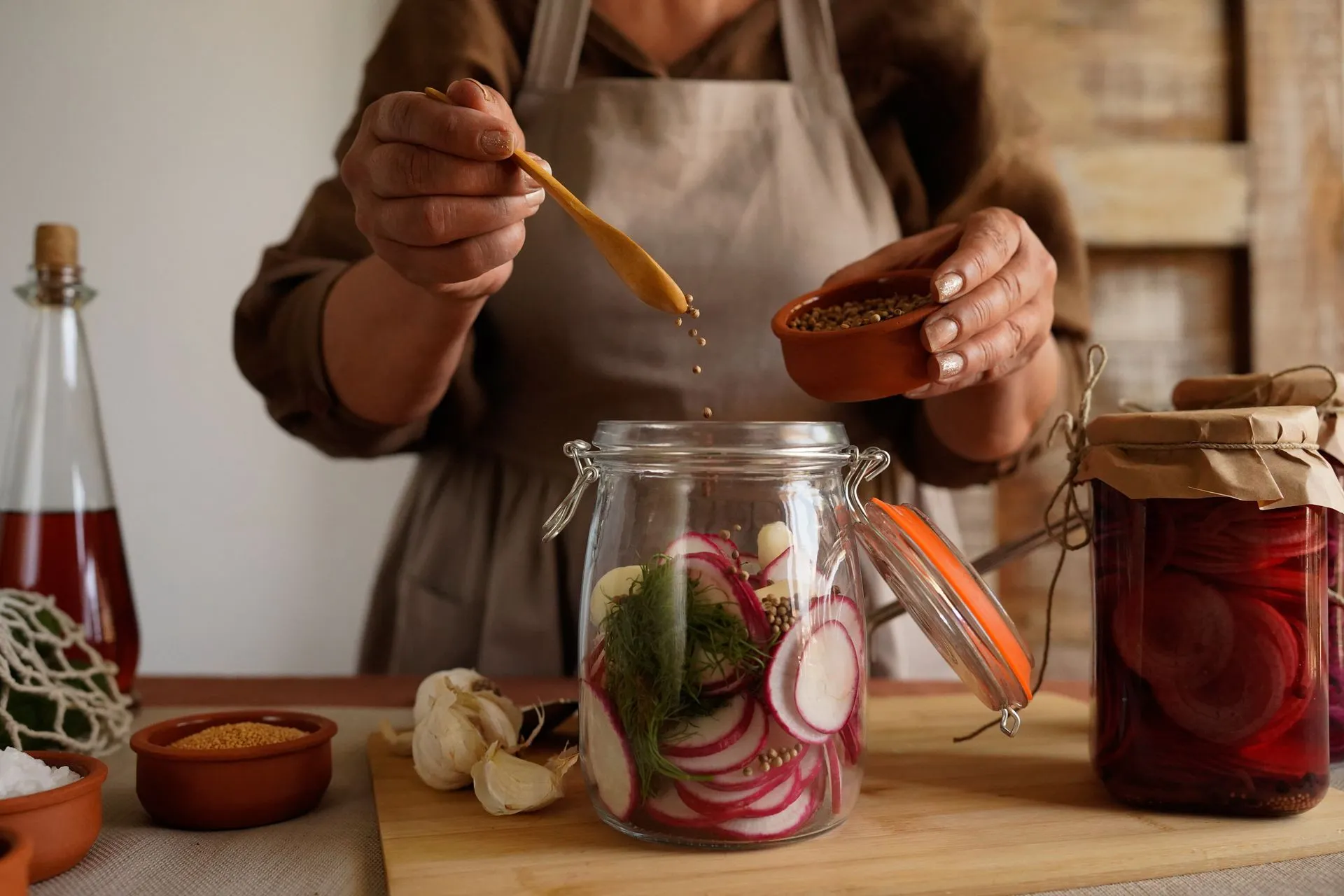Handen vullen een pot met ingemaakte groenten.