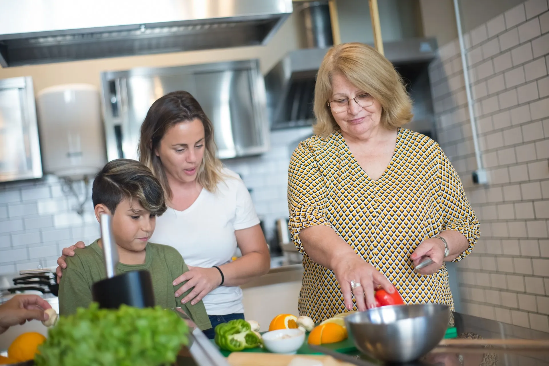 Twee vrouwen en een kind bereiden groenten in de keuken