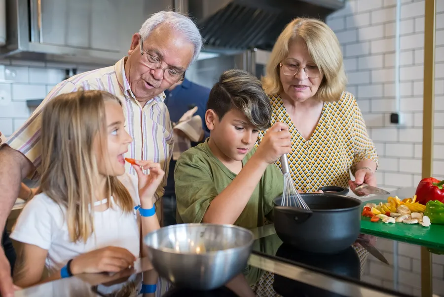Ouderen en kinderen bereiden samen groenten in de keuken