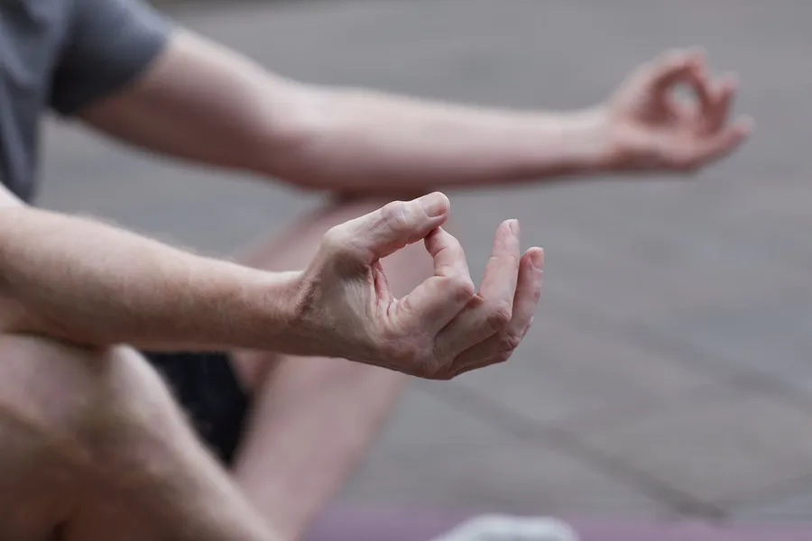 Handen rusten op de knieën tijdens meditatie