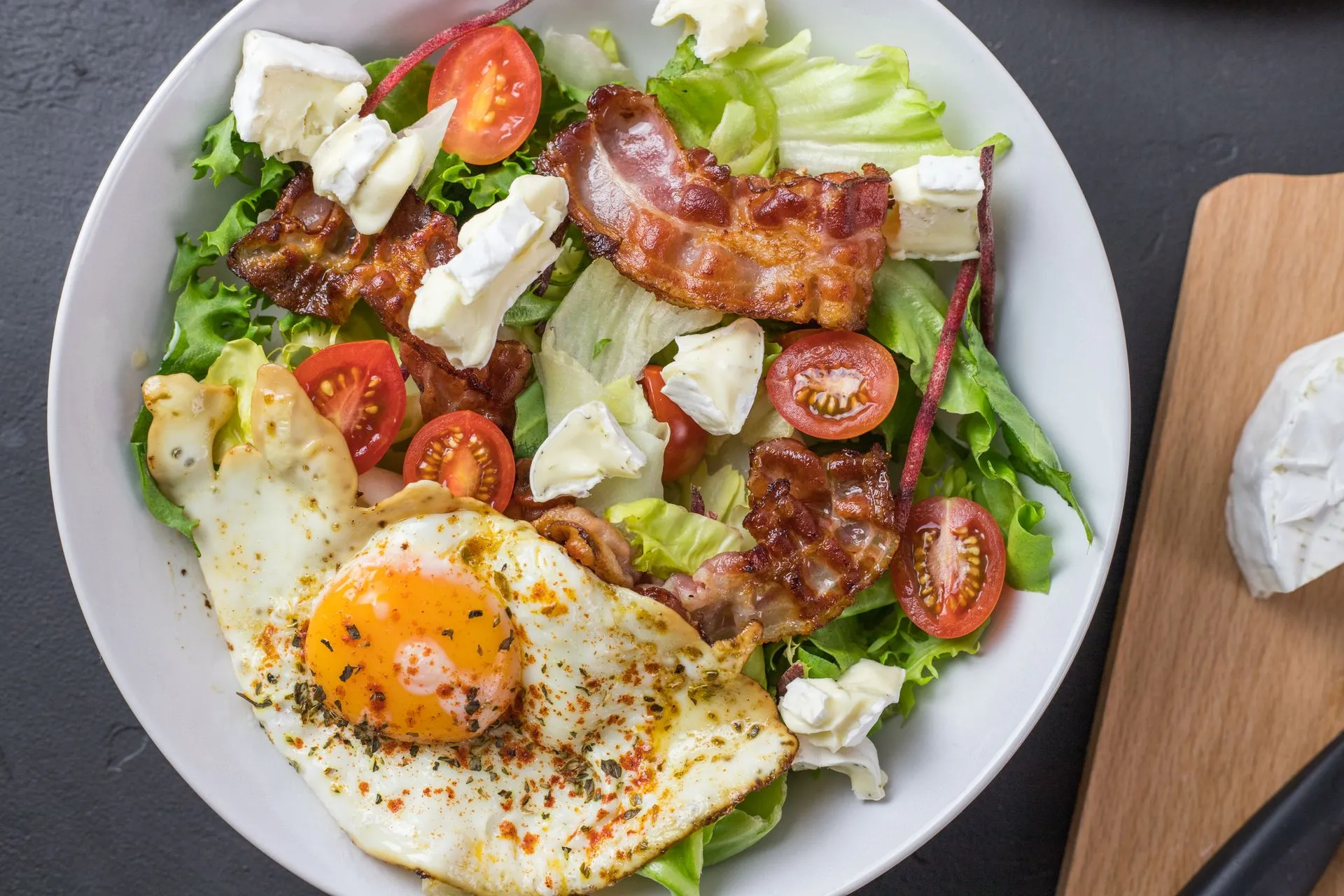 Verse ketosalade met spek, ei, feta en tomaat.