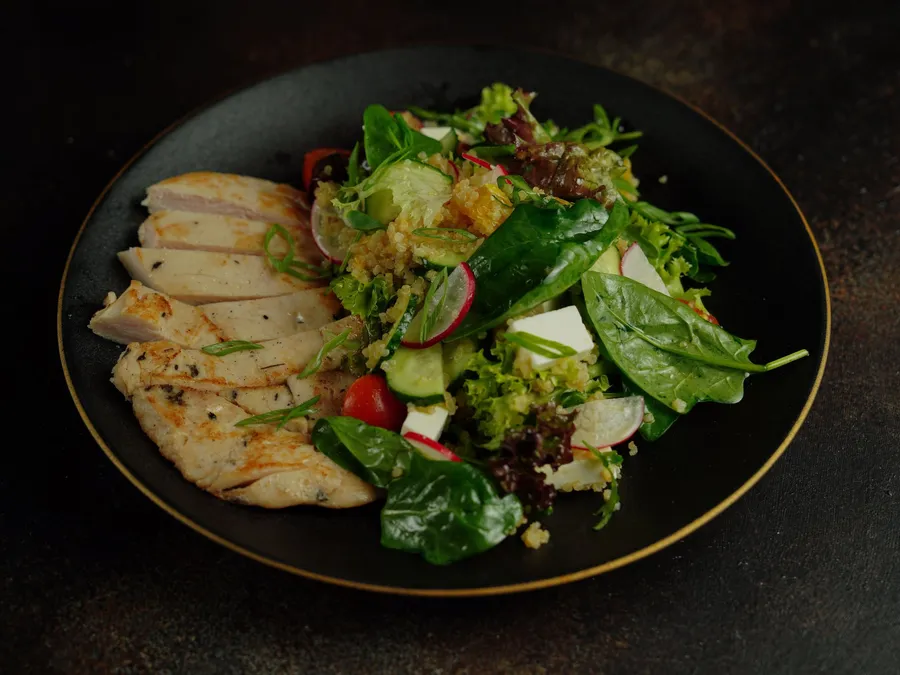 Bord met kip en een groene salade
