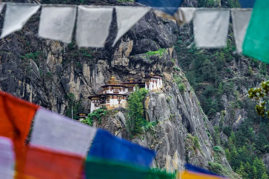 Gebedsvlaggen met het Paro Taktsang-klooster in Bhutan op de achtergrond