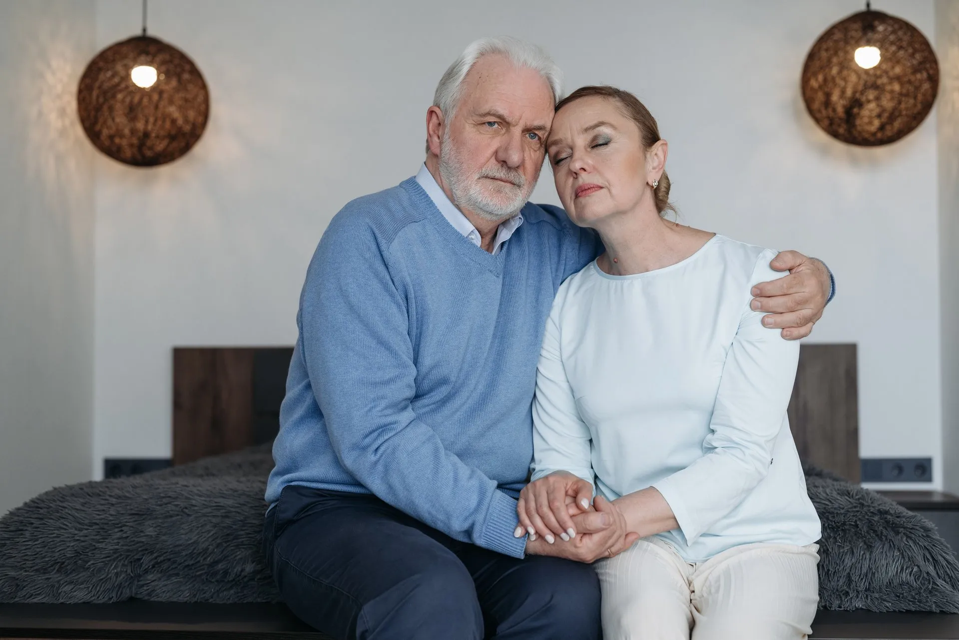 Ouder stel zit samen op bed