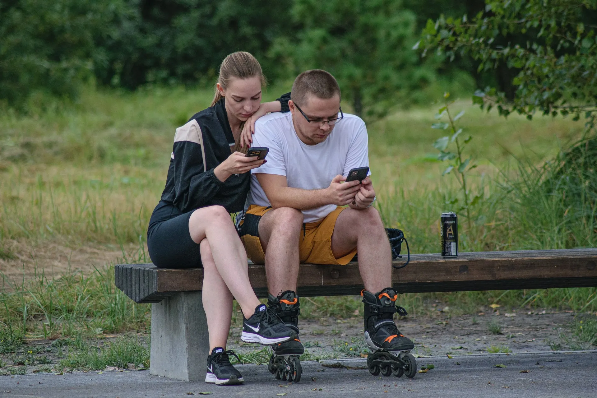 Twee mensen kijken op hun telefoon naast elkaar