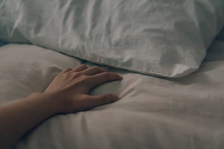 Hand rust op een kussen in bed