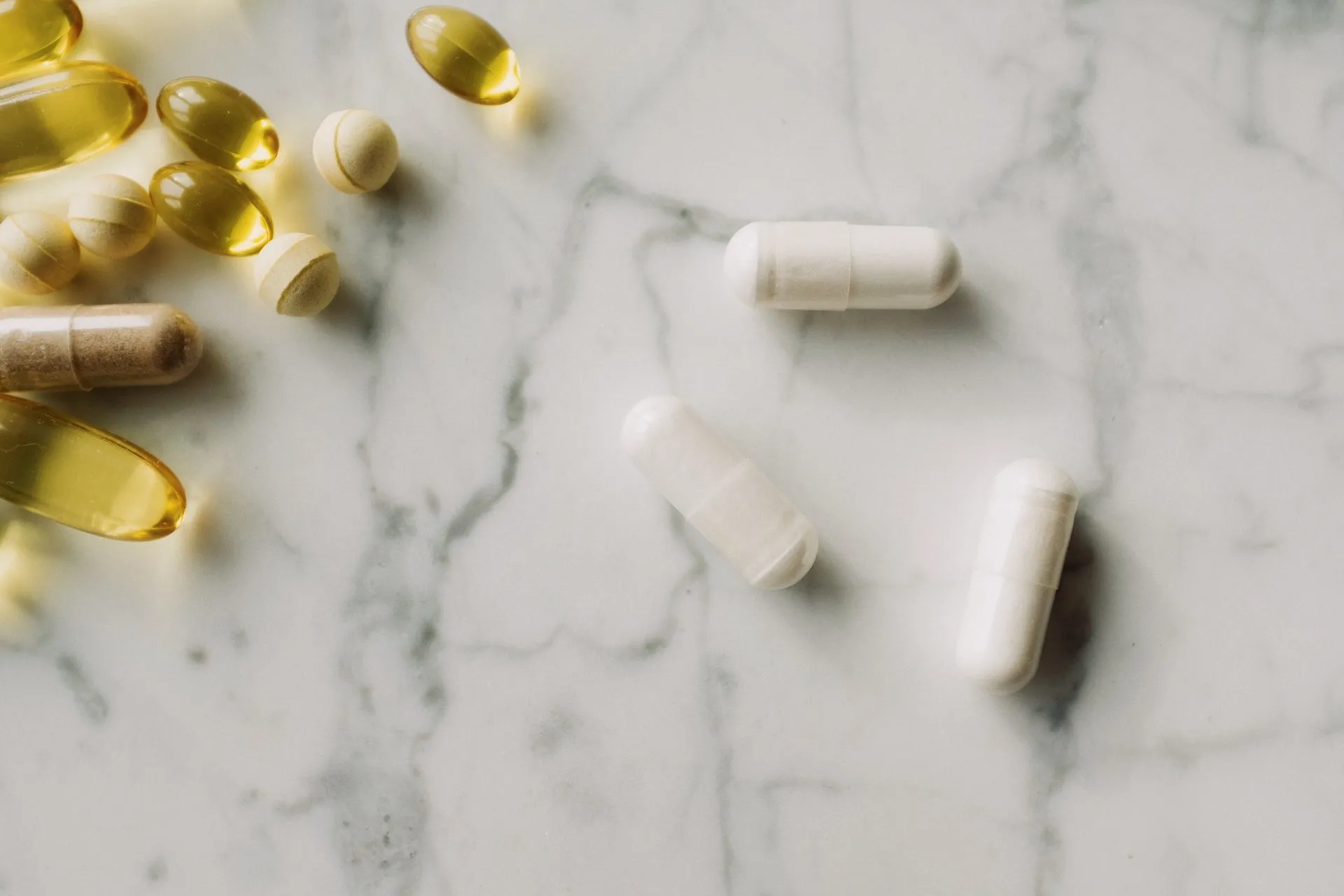 Gele en witte capsules op een lichte ondergrond