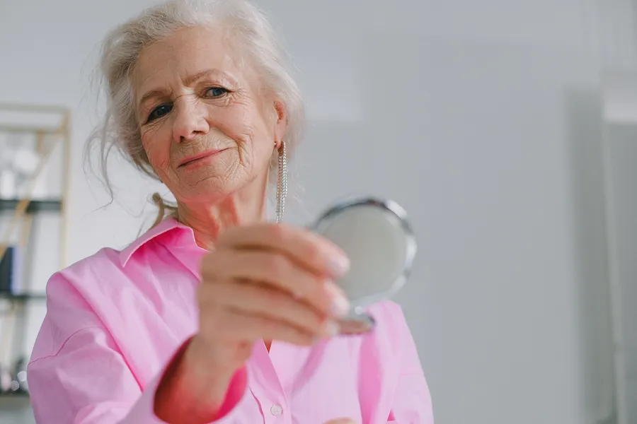 Oudere vrouw houdt een handspiegel vast