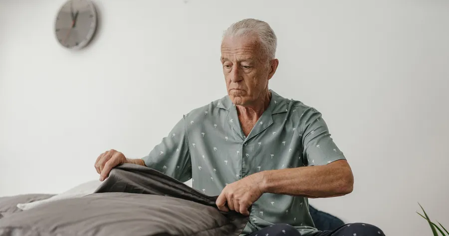 Oudere man doet een kussensloop om zijn kussen