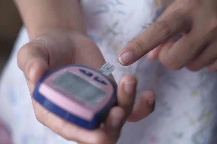 Volwassene meet de bloedsuiker met een glucosemeter.