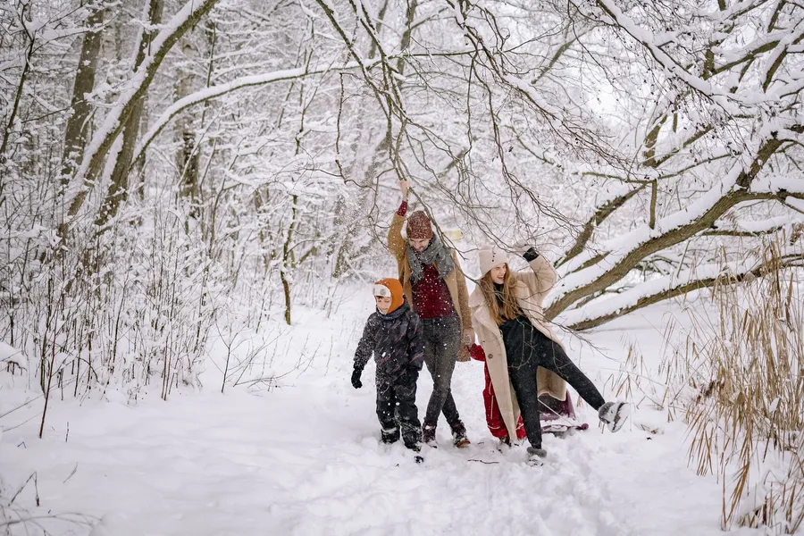 Gezin wandelt door een besneeuwd bos
