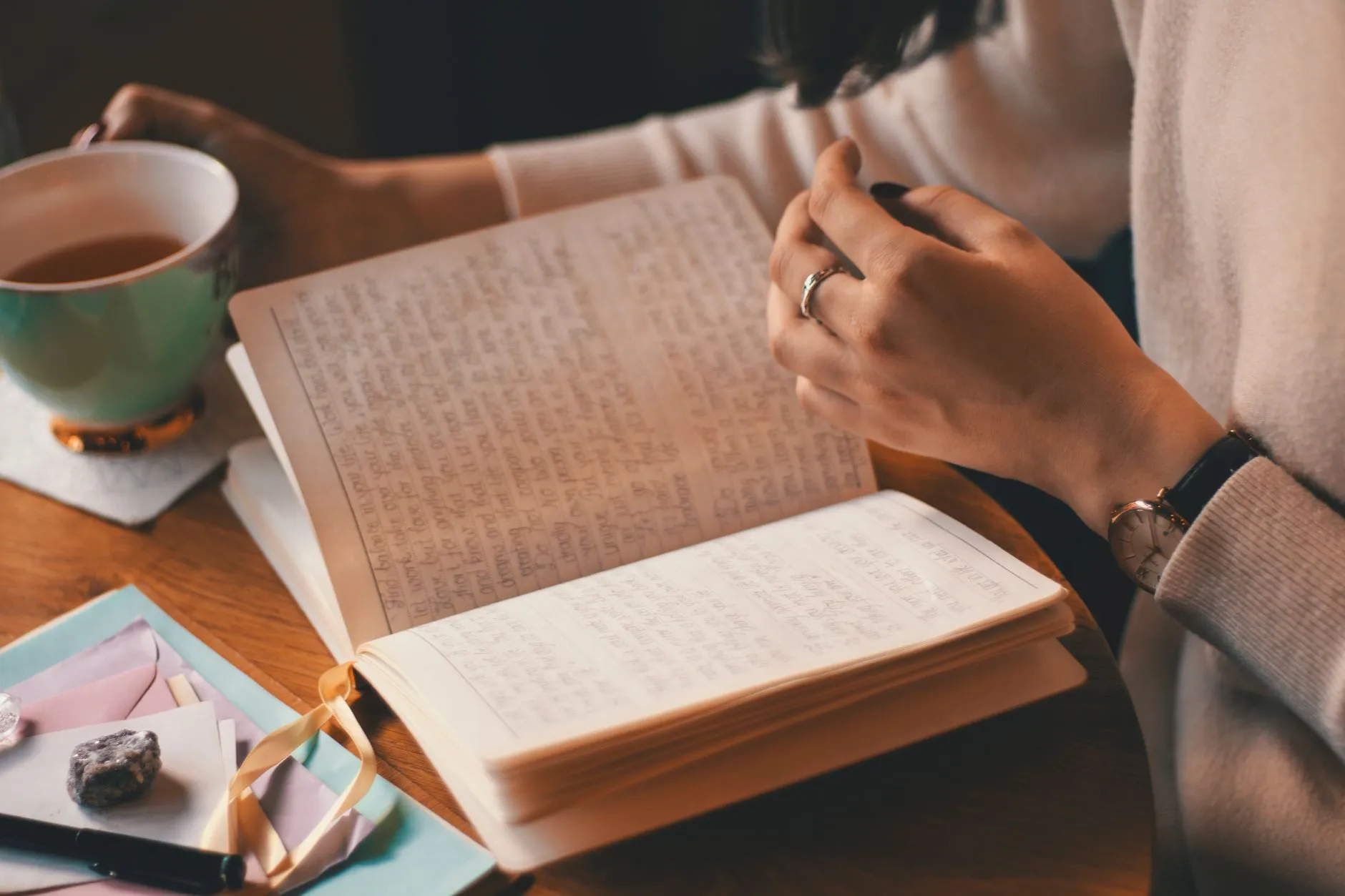 Vrouw schrijft in een dagboek met thee, PMS bijhouden