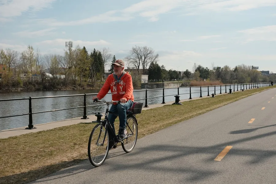 Oudere man fietst langs de rivier, bewegen helpt bij prostaatklachten