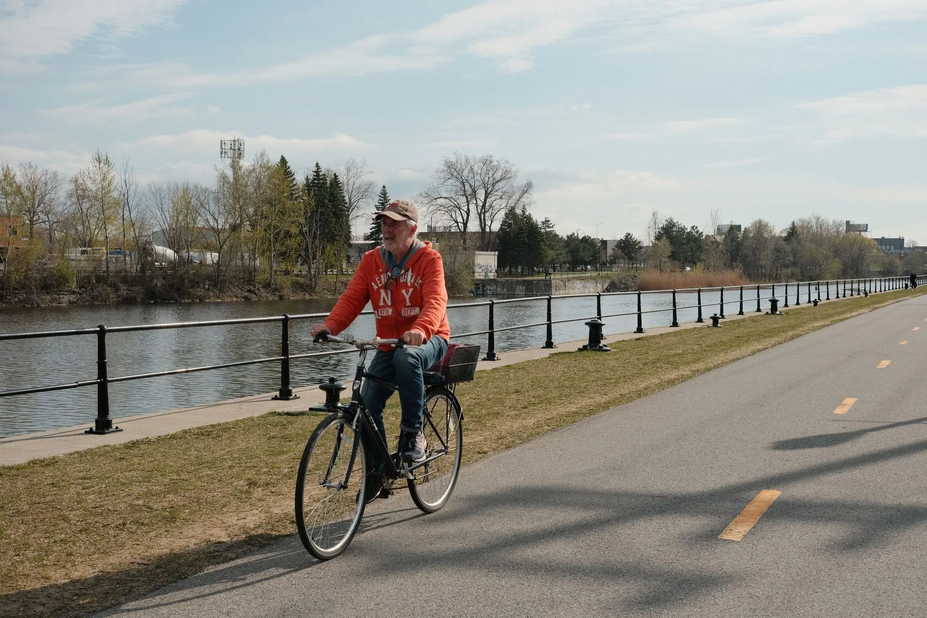 Oudere man fietst langs de rivier, bewegen helpt bij prostaatklachten