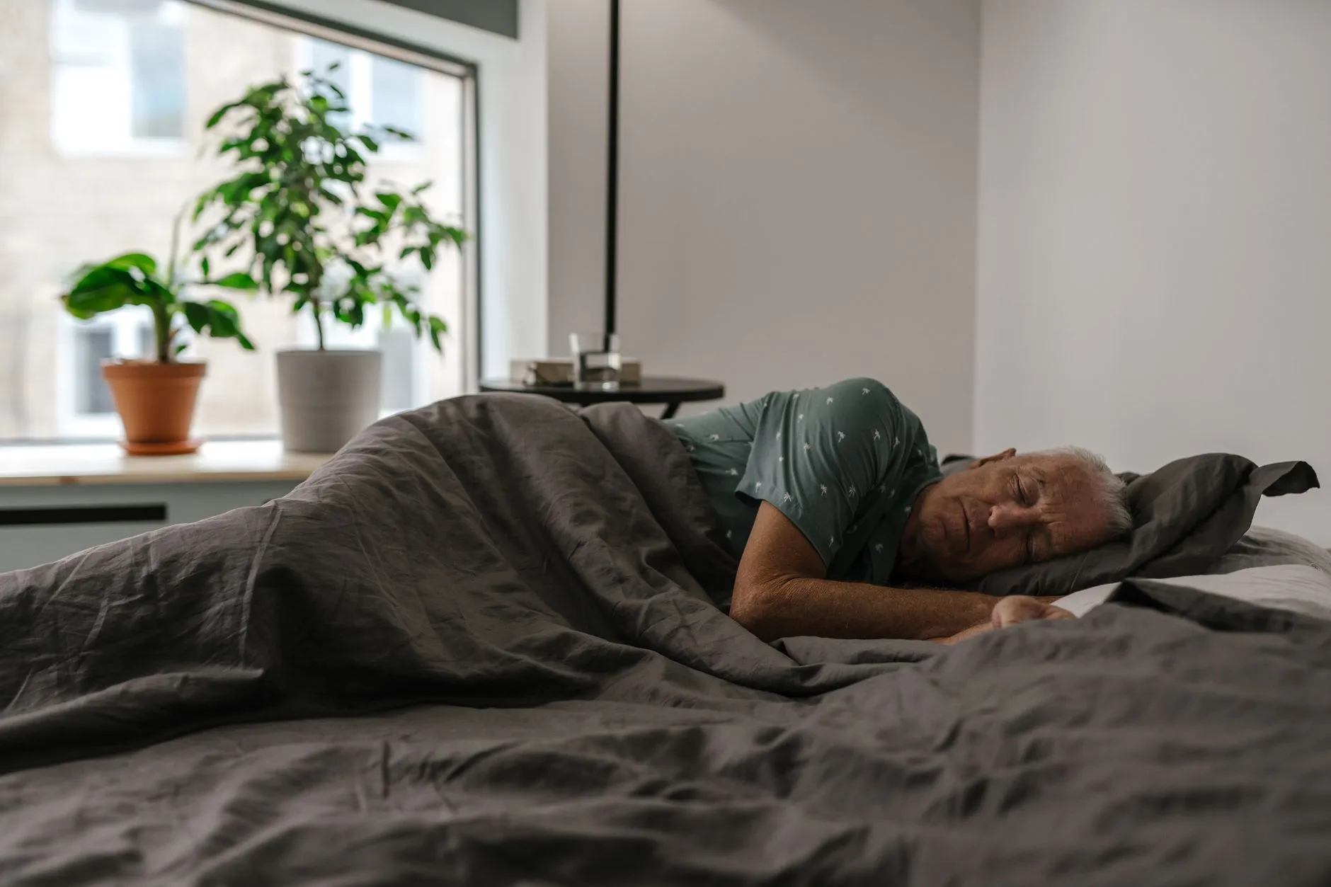 Oudere man slaapt rustig in slaapkamer met daglicht