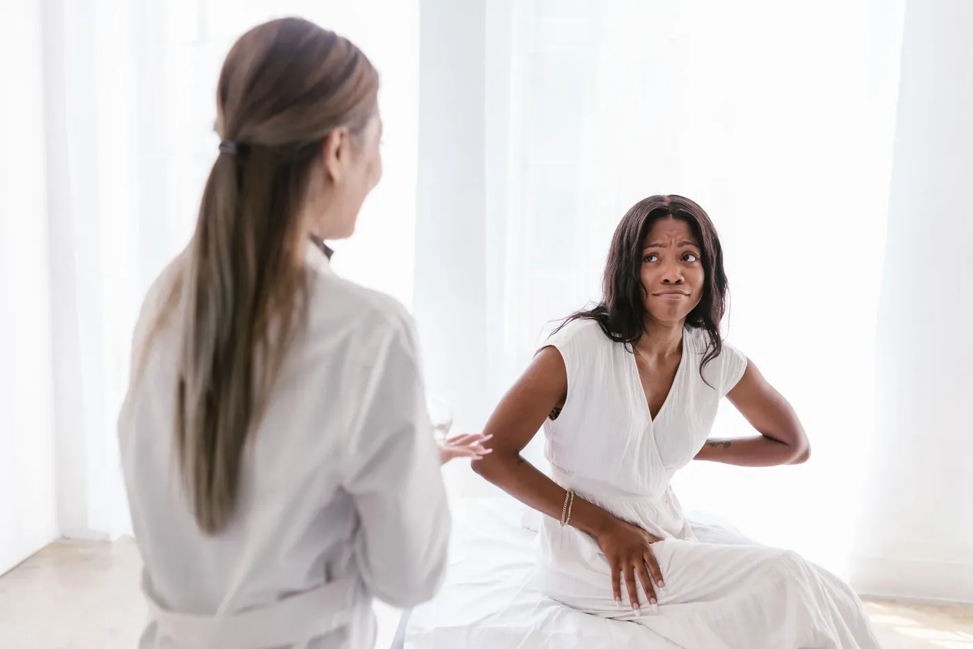 Vrouw met buikpijn in gesprek met een arts