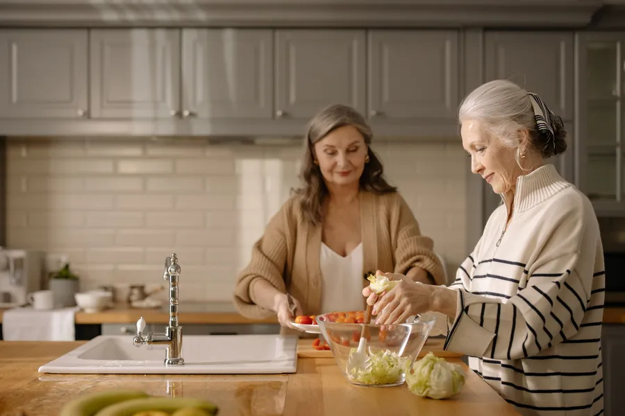 Voeding voor ouderen: twee vrouwen maken verse salade